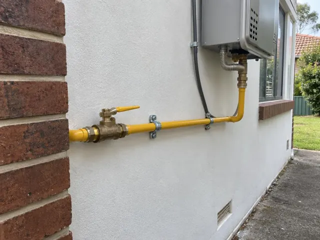 Exterior gas pipe and valve on a white house wall beside a window in Toongabbie